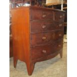 An early 19th century bowfronted bedroom chest of two short over three long graduated drawers,