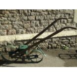 A vintage Planet Junior seed drill no.300, with two spoke wheels and wooden shafts/handle