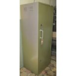 A light sage green painted heavy gauge steel floorstanding gun cabinet enclosed by a full length