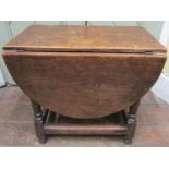 A small old English oak drop leaf occasional table on turned supports, 53cm long x 50cm high