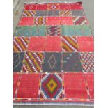 A Dhurrie flat weave carpet with a single side square pattern with random motifs, 250cm 160cm approx