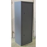 A small steel gun cabinet enclosed by a single door with two locks, 30cm wide x 22cm deep x 82cm