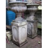 A pair of weathered cast composition stone garden urns with circular lobed bowls with fixed socles
