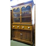 A Victorian stripped pine kitchen dresser in two sections, the lower enclosed by a pair of arched