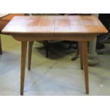 A mid 20th century walnut veneered and beechwood pull out extending dining table of rectangular