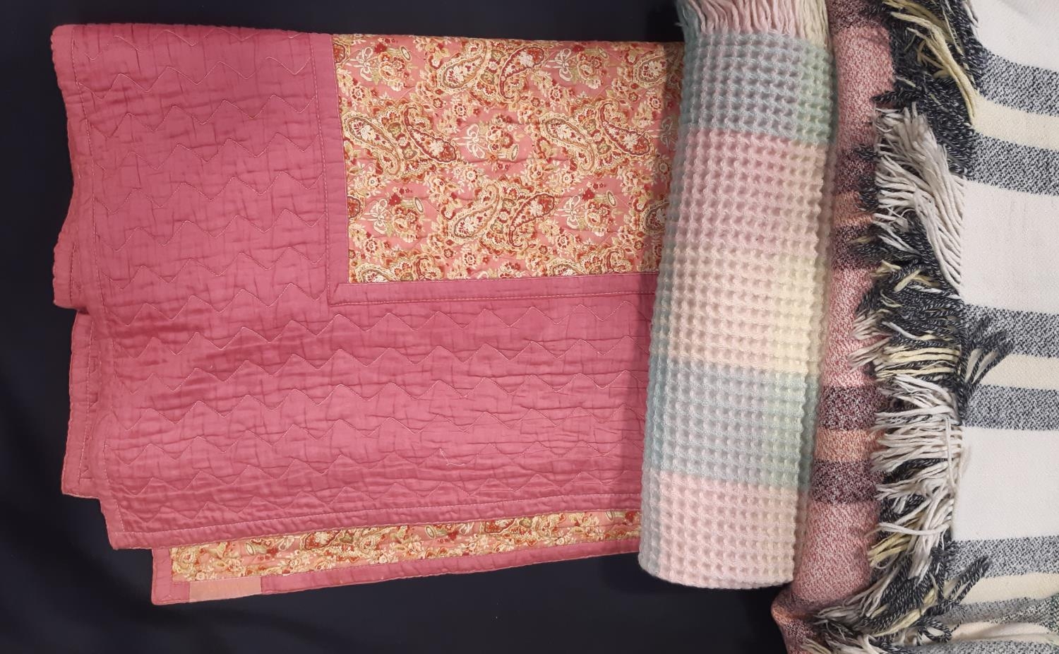 Vintage reversible machine stitched quilt, with blocks of pink contrasted with multicoloured paisley