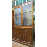 A Victorian mahogany cabinet the lower section enclosed by panelled doors, the upper section by