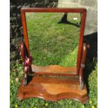 A Victorian mahogany toilet mirror, the platform base with shaped outline on scrolled toes