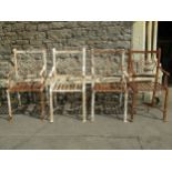 A set of four old iron strapwork garden chairs, with entwined and scrolled backs and lattice seats