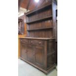A good quality Old English style oak dresser, the base enclosed by three rectangular moulded
