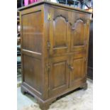 A good quality reproduction oak side cupboard in the old English style enclosed by four fielded