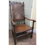 A Carolean walnut elbow chair with carved and pierced detail, scrolled arms, barley twist and