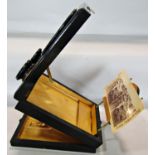 A Victorian ebonised folding stereoscope and postcard magnifying viewer and approximately 100 slides