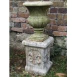 A small weathered marble urn with flared rim, 30 cm in diameter x 38 cm high, raised on an