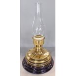 A squat Victorian brass candlestick with a flared wavy stand raised on a marble base, with an