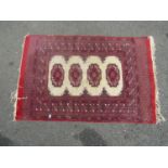 A small Turkoman rug with a central fawn panel and four medallions, 120cm x 80cm
