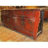 A Chinese lacquered dresser enclosed by two pairs of doors and four drawers, in pine, with