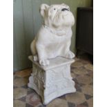 A cast composition stone garden ornament in the form of a seated bulldog raised on associated