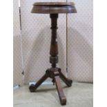 A late Victorian walnut shaving stand, the circular top enclosing two hinged box compartments raised