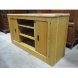 A good quality contemporary low oak cupboard, partially enclosed by two sliding shelved compartments