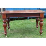 A mahogany writing table, the rectangular top with moulded outline, rounded corners and inset