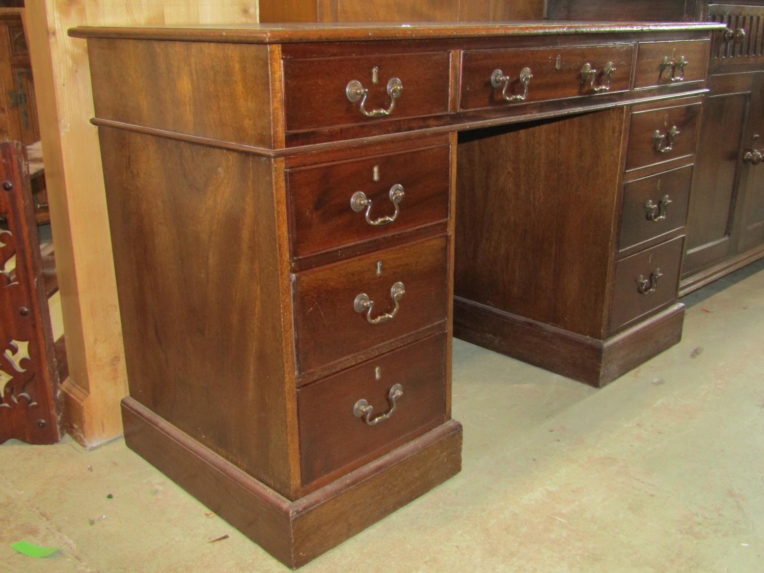 A reproduction Georgian style mahogany kneehole twin pedestal desk with inset leather writing