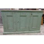 A 19th century pine side cupboard enclosed by three rectangular moulded panelled doors flanked by