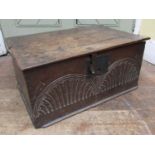 An 18th century oak bible box with rising lid the front elevation with repeating lunette carved