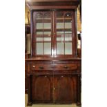 Late Regency period mahogany secretaire bookcase enclosed by a pair of oval panelled doors,