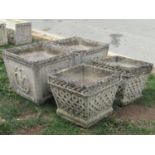 A pair of weathered cast composition stone planters of square tapered form with repeating fleur-de-