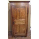 An early 19th century oak livery cupboard enclosed by a panelled door, within a pegged frame with