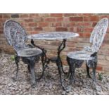 A painted and weathered cast aluminium garden terrace table of circular form with decorative pierced
