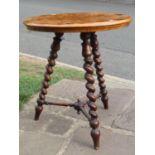 A 19th century occasional table raised on three barley twist supports, the specimen wood top with