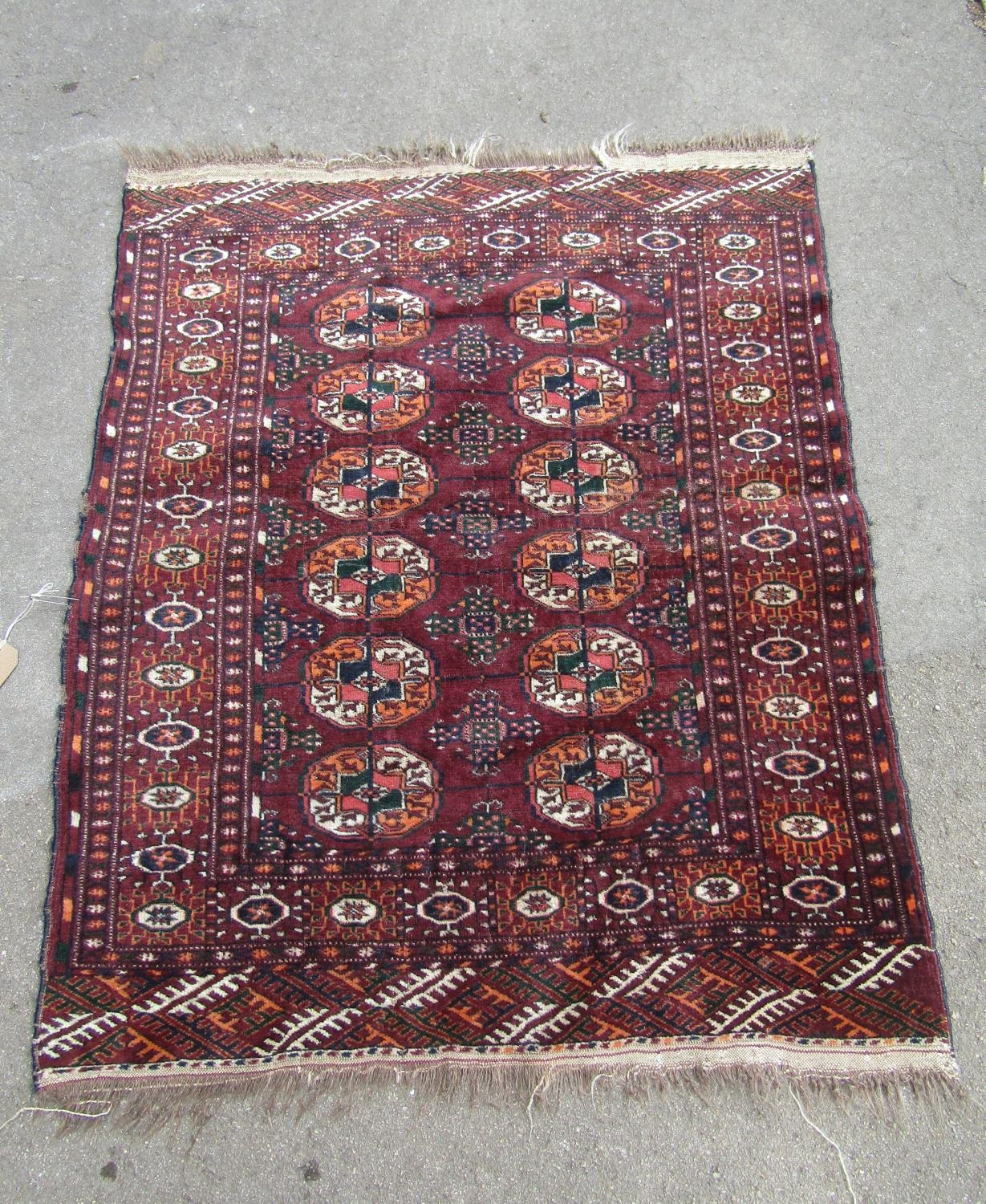 A Turkoman rug with two rows of elephant foot gul on purple ground, 110cm x90cm