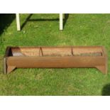 A vintage cast iron pig feeding trough of rectangular form with two run divisions, 90cm long x