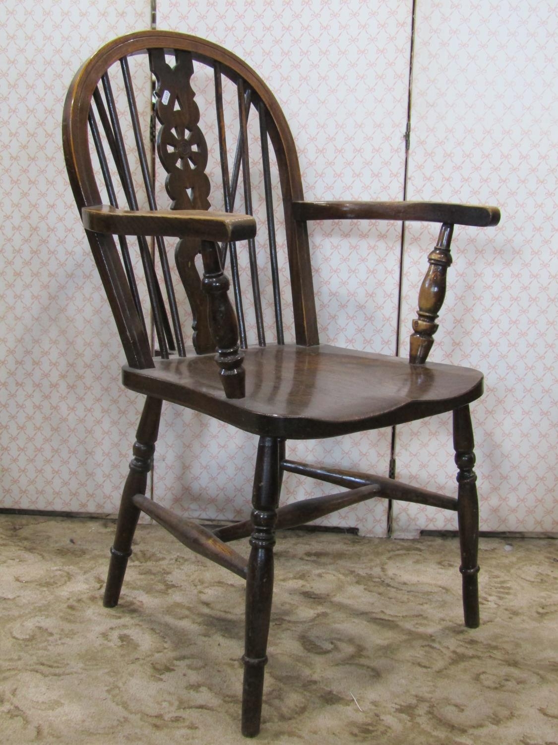 A Windsor stained elm and beechwood hoop and stick back open armchair with pierced wheel back over a