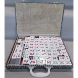 A Mahjong game in a silk lined cardboard box with composite tiles.