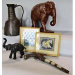 A large carved wooden elephant, a leather clad model of an elephant, a model flintlock pistol, a