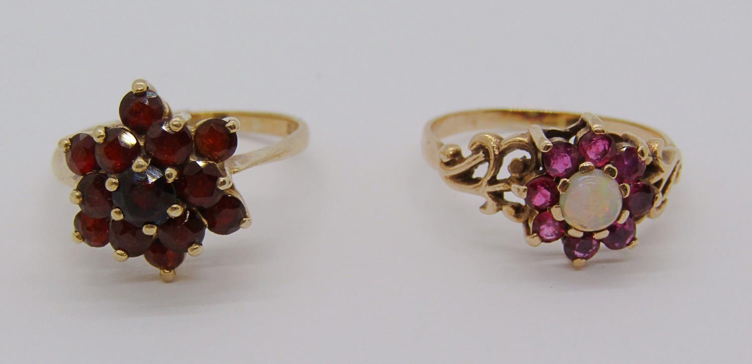 9ct ruby and garnet cluster ring with scrolled shoulders, together with a further 9ct garnet cluster