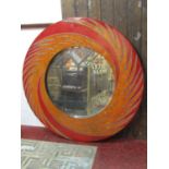 A large contemporary wall mirror of circular form with wide painted swirling patterned frame,