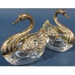 A pair of glass salt and pepper pots in the form of silver swans with articulated wings, stamped