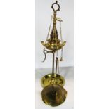 A brass Roman style whale oil lamp with three spouts on an adjustable stand.