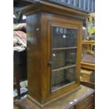 A 19th century oak hanging wall cabinet enclosed by a rectangular segmented moulded glazed panel