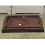 A set of three graduated Chinese hardwood tea trays of rectangular form with pierced handles and