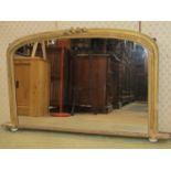 A Victorian overmantel mirror with simple moulded gilt arched frame raised on ceramic bun feet,