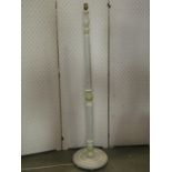 A turned wooden standard lamp with reeded and fluted stem, raised on a circular platform base with