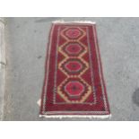 A Turkoman type carpet with four repeating diamond shaped medallions , 164cm x 83cm approx