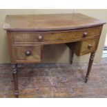 An early 19th century mahogany bow fronted side table enclosing three drawers on turned supports,