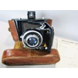 A vintage French Kinax bellows folding camera in its original leather case and strap, and receipt