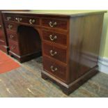 An inlaid Edwardian mahogany desk, fitted with an arrangement of nine drawers, crossbanded in